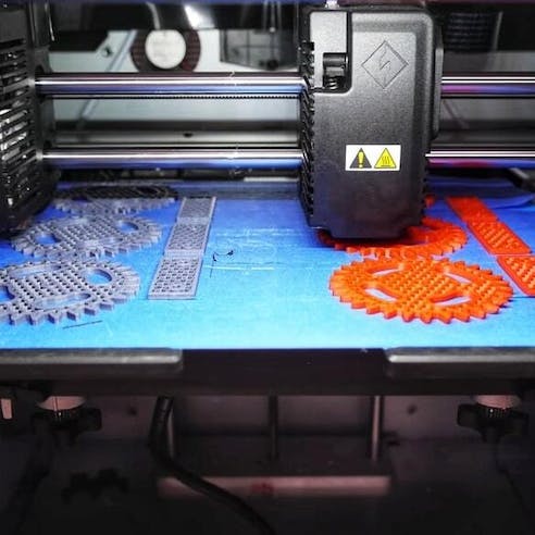 Large gray and orange 3D printed parts. Image Credit: Shutterstock.com/Cheshiry_cat